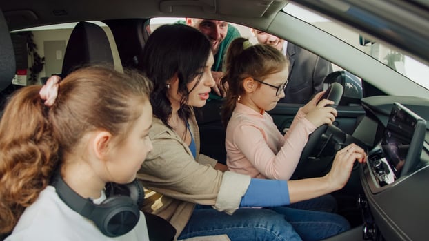 In a modern car dealership, a manager shows and advises a young family with children about buying or test driving a modern car. The concept of buying or leasing a new car photo