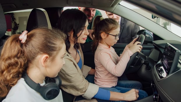 In a modern car dealership, a manager shows and advises a young family with children about buying or test driving a modern car. The concept of buying or leasing a new car. photo