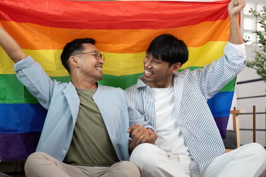 LGBT couple sharing a joyful moment with rainbow flag photo