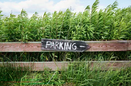 Sign that says parking is on a wooden fence photo