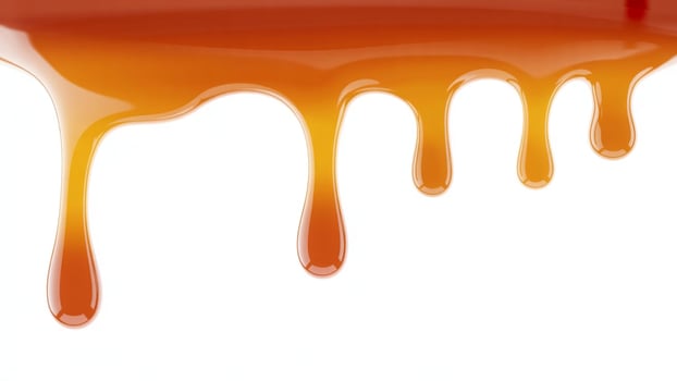 Close up of caramel sauce dripping down against a plain white background surface photo