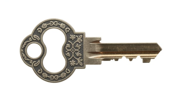 Close up of an ornate metal key with floral designs on a white background studio photo
