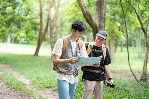 Navigating Nature Together. Father and son reading a map while hiking. photo
