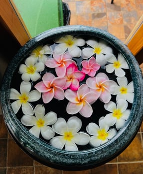 A bowl filled with flowers on a tile floor photo