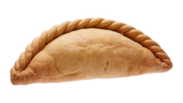 Close up shot of a baked empanada with a twisted crust on a white background in studio light photo