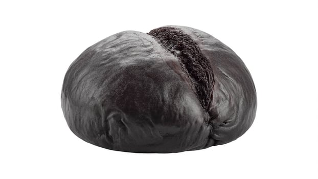 Close up shot of a single dark brown loaf of bread on a white background in soft lighting photo