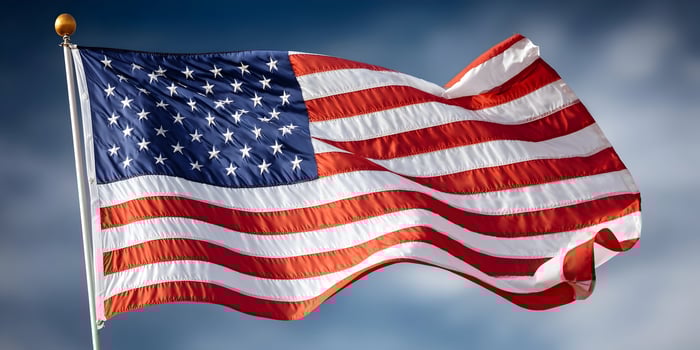 American Flag Waving in the Wind Blue Sky Background photo