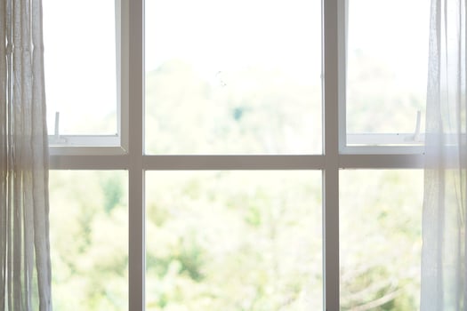 Minimalist white box shaped window with curtains open during the day photo