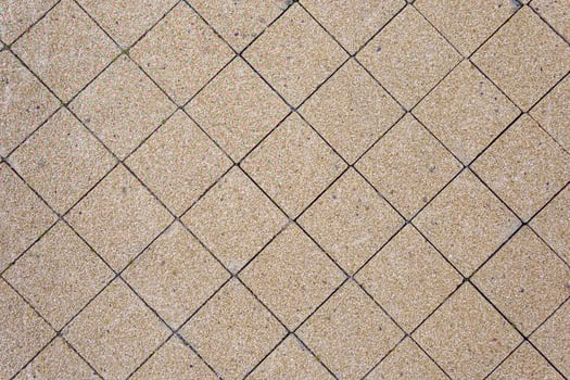 Tiles of stone chips cover the surface of the ground in the city. Green sprouts sprout through the tiles. Abstract background. photo