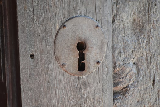 Rustic keyhole on weathered wooden door in Brihuega spain for architectural design and historic decor. Iglesia de San Felipe. Church Saint Felipe in Brihuega, Guadalajara, Spain photo