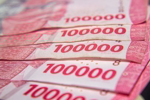 Close-up of Indonesian 100,000 Rupiah banknotes in pink tones. For business concept. photo