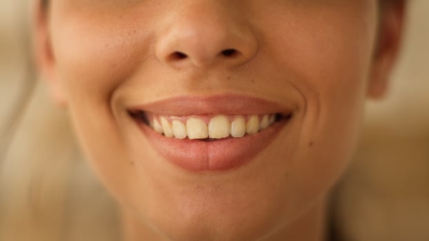 Close up face lips of unrecognizable Indian Arabian woman girl female lady smiling smile sensuality toothy white teeth beauty lipstick make up health medicine cropped view indoors feminine cosmetology photo