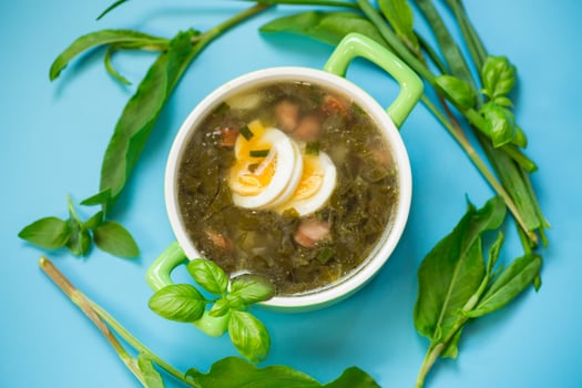 Traditional Ukrainian sorrel borscht with egg on blue background photo