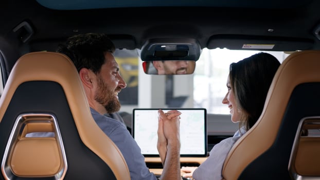 Back view happy family Caucasian couple inside automobile buying auto smiling looking in each other holding hands bonding travel man guy male boyfriend husband in car woman girl female girlfriend wife photo