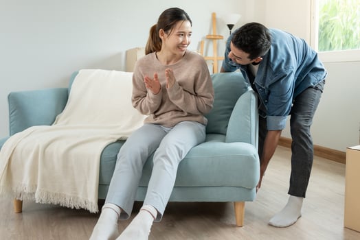 Moving house, relocation. Woman feels good and is teasing her husband, inside the room was a cardboard box containing personal belongings and furniture. move in the house or condominium, photo