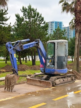 Excavator with Full Bucket on Urban Paved Lot photo