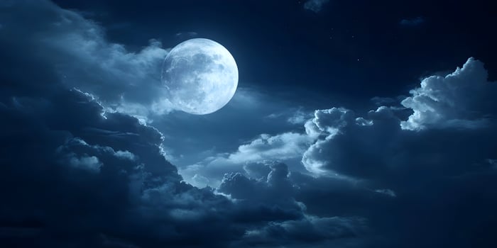 a full moon is seen in the sky above clouds photo