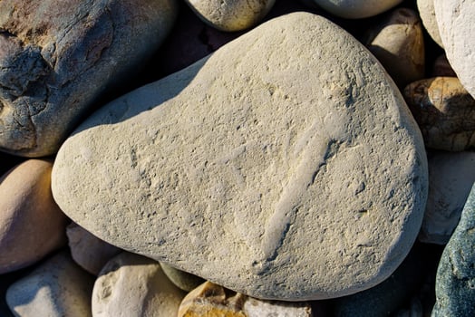 Serene Stone Composition A Naturally Textured Rock Amidst a Bed of Smooth River Stones photo