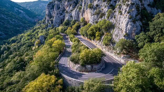 Vibrant nature photo with road winding across terrain