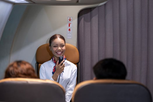 African flight attendant greeting the passenger to welcome on board to the flight and reporting the attitude, weather and route to the destination airport photo