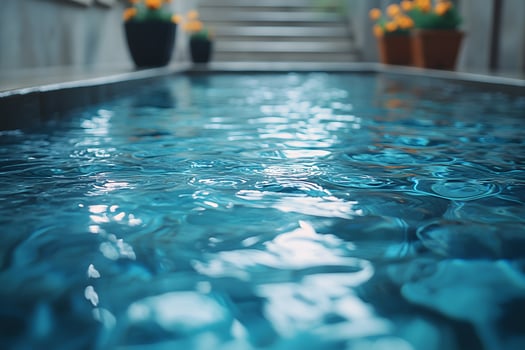 Tranquil Poolside Oasis with Rippling Blue Water and Potted Flowers photo