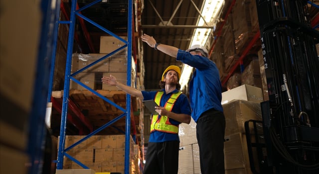 A bunch of warehouse workers are reviewing the list of items based on the documentation,154 photo