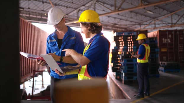 A bunch of warehouse workers are reviewing the list of items based on the documentation,86 photo