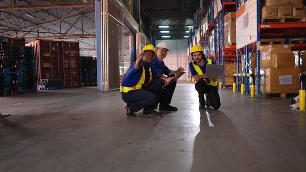 A bunch of warehouse workers are reviewing the list of items based on the documentation,10 photo