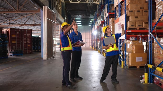 A bunch of warehouse workers are reviewing the list of items based on the documentation,5 photo