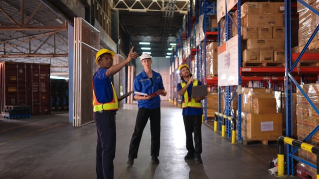 A bunch of warehouse workers are reviewing the list of items based on the documentation,3 photo
