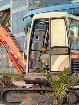 Urban Excavator Framed by Water Slide and Building Site photo
