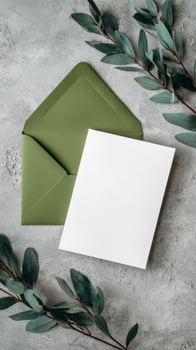 Elegant Green Envelope and Blank Card With Leaves on a Textured Surface. photo