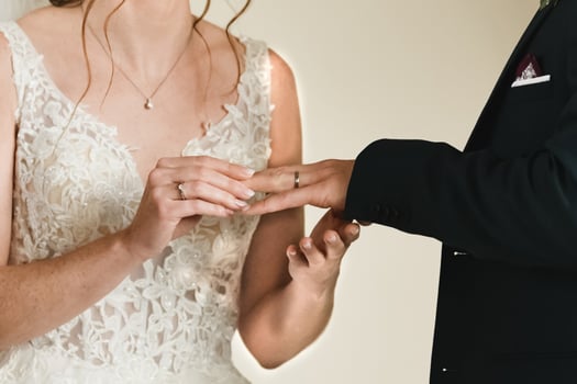 The bride puts a ring on the groom's finger photo