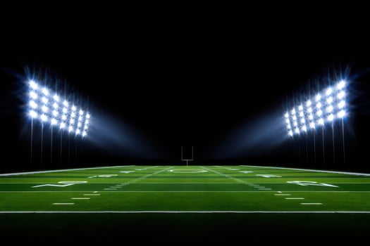 Illuminated American Football Field at Night with Bright Stadium Lights and Goal Post in the Distance photo