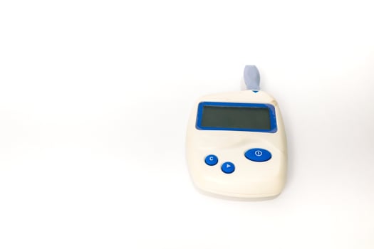 Close-up studio shot of a portable blood glucose meter on a white background, for diabetes monitoring and healthcare photo