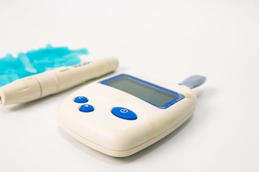 Close-up of Glucose Meter, Lancing Device, and Lancets on a White Background for Diabetes Testing photo