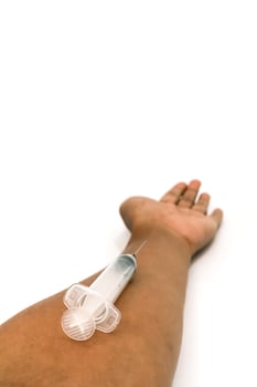 Close-up of an arm receiving an injection with a syringe on a white background photo