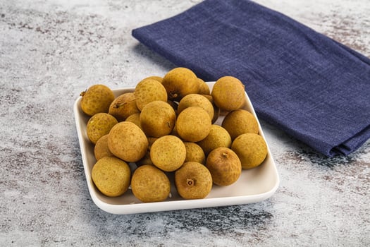 A white plate with a bowl of olives and a blue napkin photo