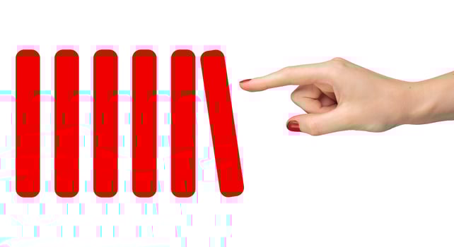 Hand pushing red domino blocks symbolizing economic crisis and market collapse. Concept of financial photo