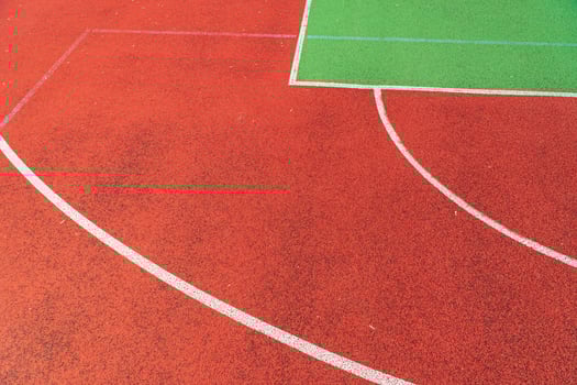 Outdoor basketball field. Detail of red outdoor basketball court photo