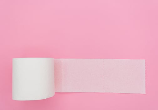 Top view of unrolled toilet paper at pink background photo