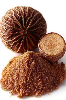 Whole nutmeg and ground spice shown on a clean white surface photo