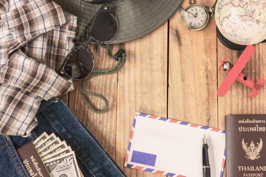 jeans, shirt, passports, banknote, sunglasses, airplane model, pocket watch, fountain pen and envelope of cost of travel prepared for the trip, Travel accessorie costumer, vintage filter photo