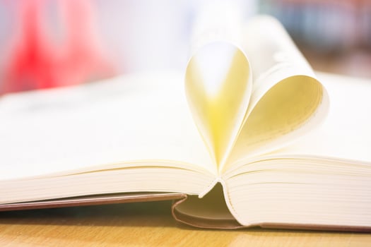 Heart from a book page vintage style close up heart shape from paper book with bokeh in soft light in morning concept for valentine's day. photo