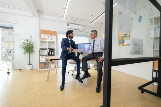 In a contemporary office, two senior executives with a mission to brainstorm and monitor,1 photo