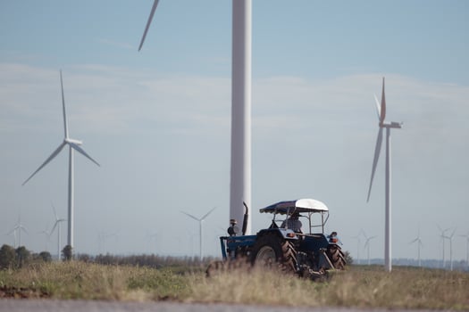 Farmers with tractors plowing the soil in a field full of windmills,57 photo