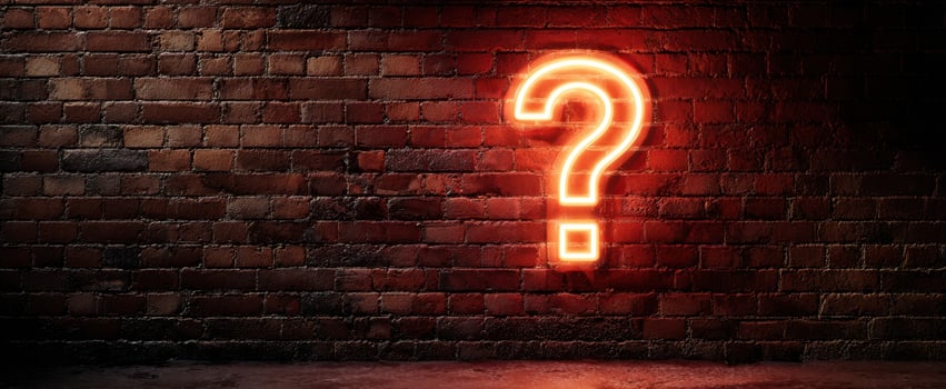 The glowing neon question mark on a stylish brick wall background. photo