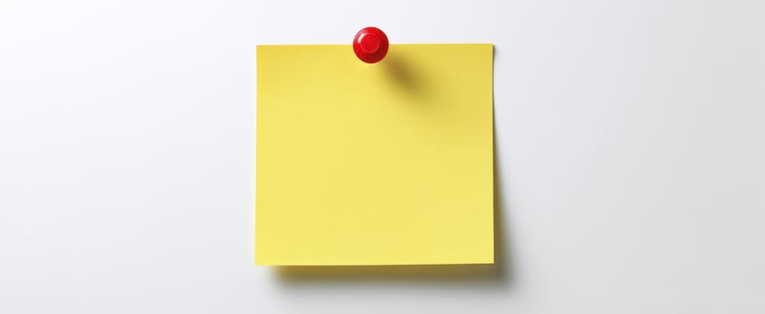The yellow sticky note pinned to a clean white background for reminders. photo