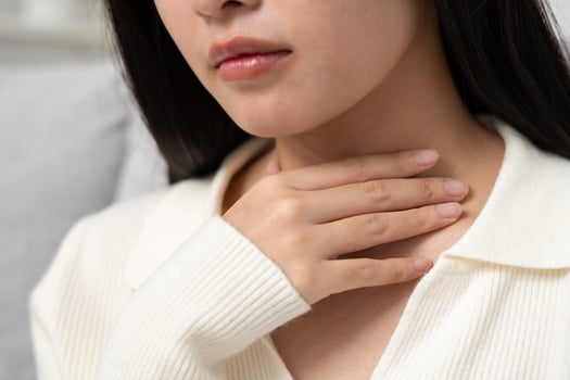 Asian woman put on neck due to a sore throat. female tonsillitis causes a inflammation. treated by taking water, taking antibiotics, consult a doctor, virus, corona virus, Influenza, flu. photo