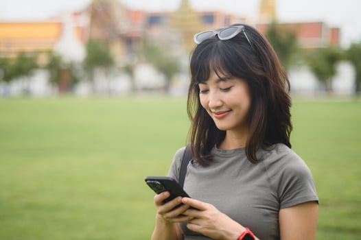 Happy solo southeast asian woman teenager blogger explorer on world travel. tourism concept to explore Asia local cultural experience in Bangkok Thailand with smartphone map guide photo